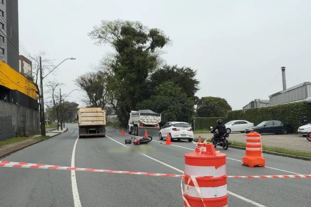 Motociclista atravessa cruzamento, bate em caminhão, para embaixo do rodado e morre atropelado em Curitiba